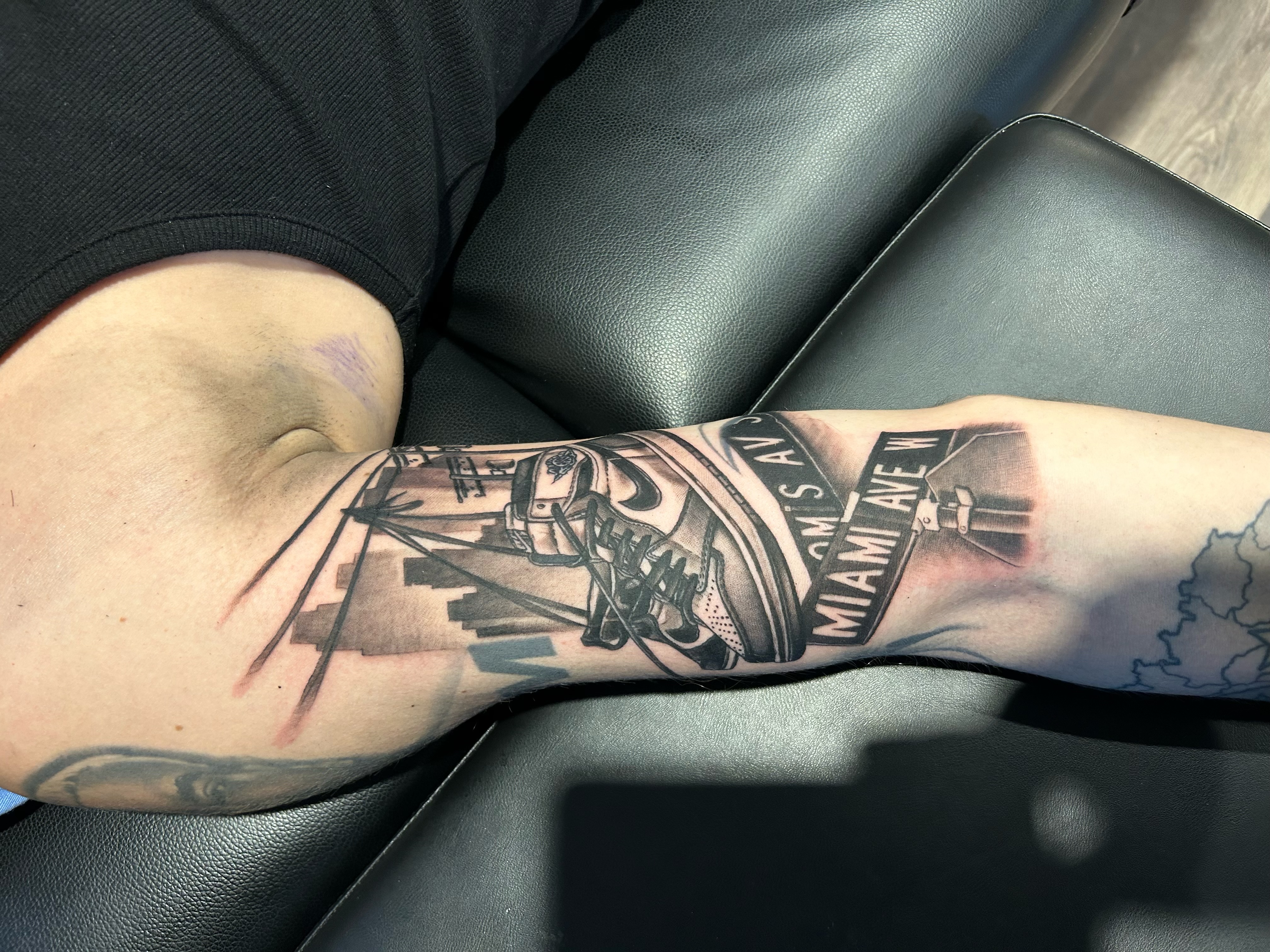 Lettering-Tattoo mit Strassenschild Miami Ave und Sneaker-Motiv