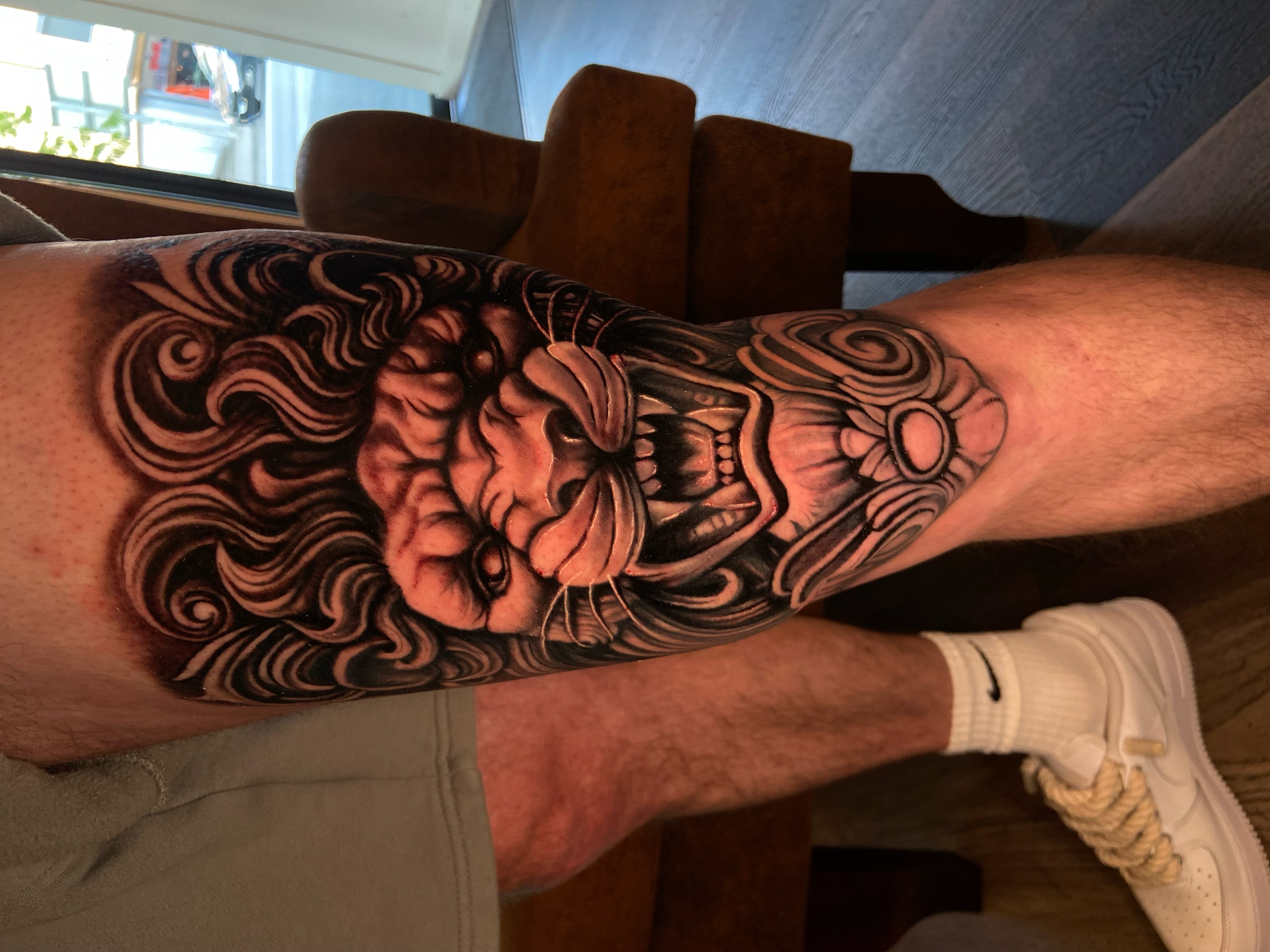 Black & Grey Tattoo mit Oni-Maske am Unterschenkel
