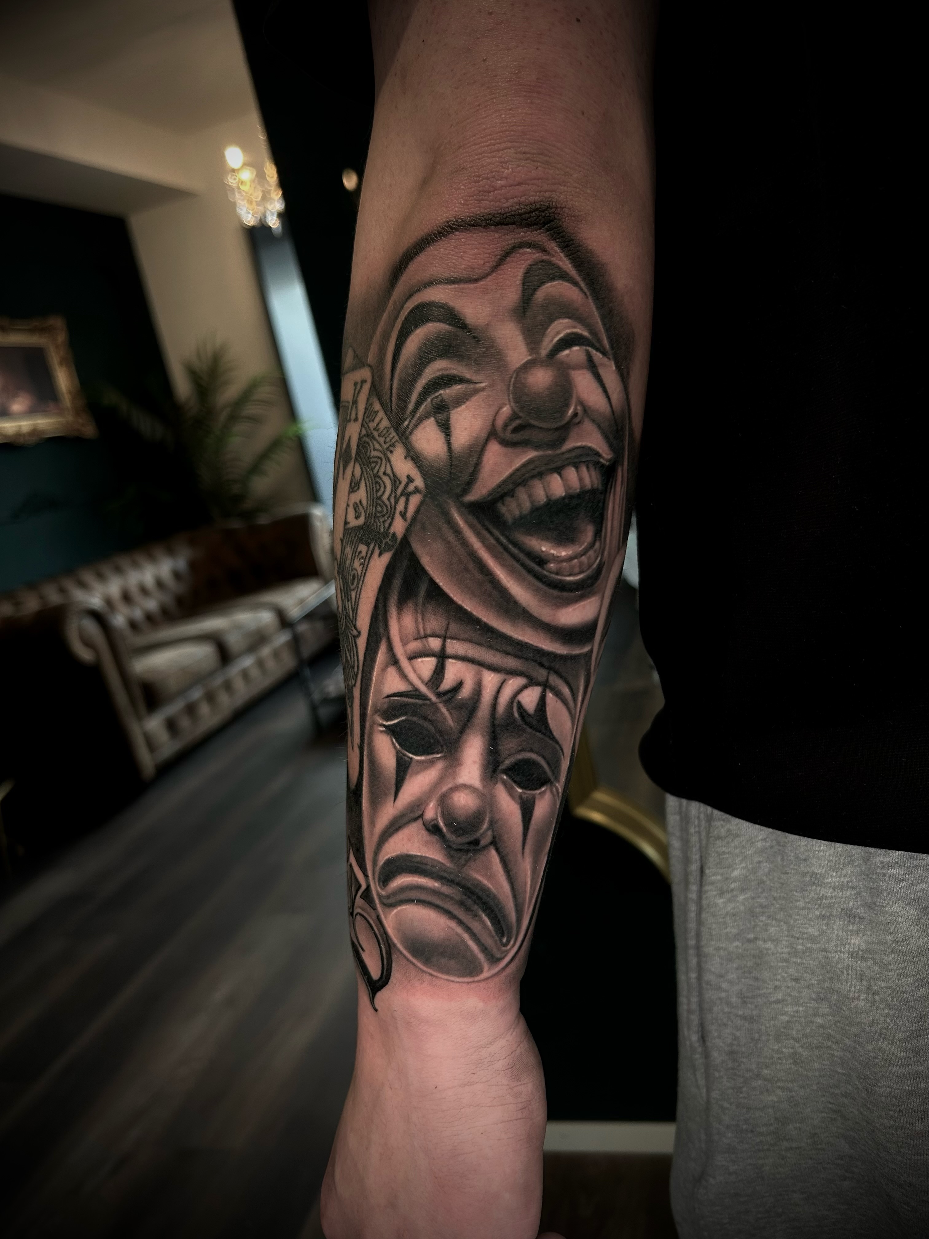 Black & Grey Tattoo mit lachender und weinender Theatermaske am Unterarm