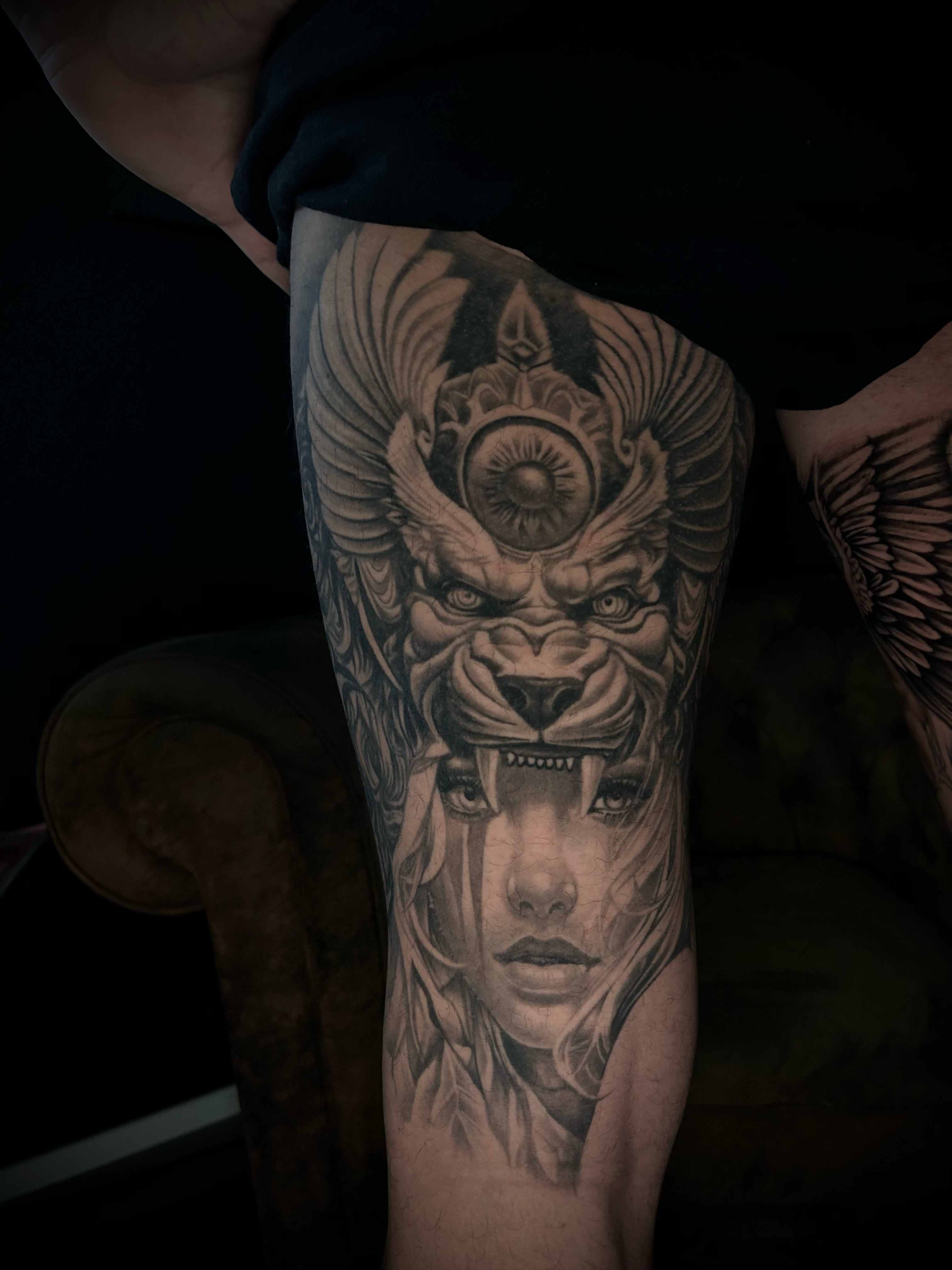 Realistisches Tattoo einer Löwin-Kopfbedeckung mit Frauenportrait am Oberschenkel