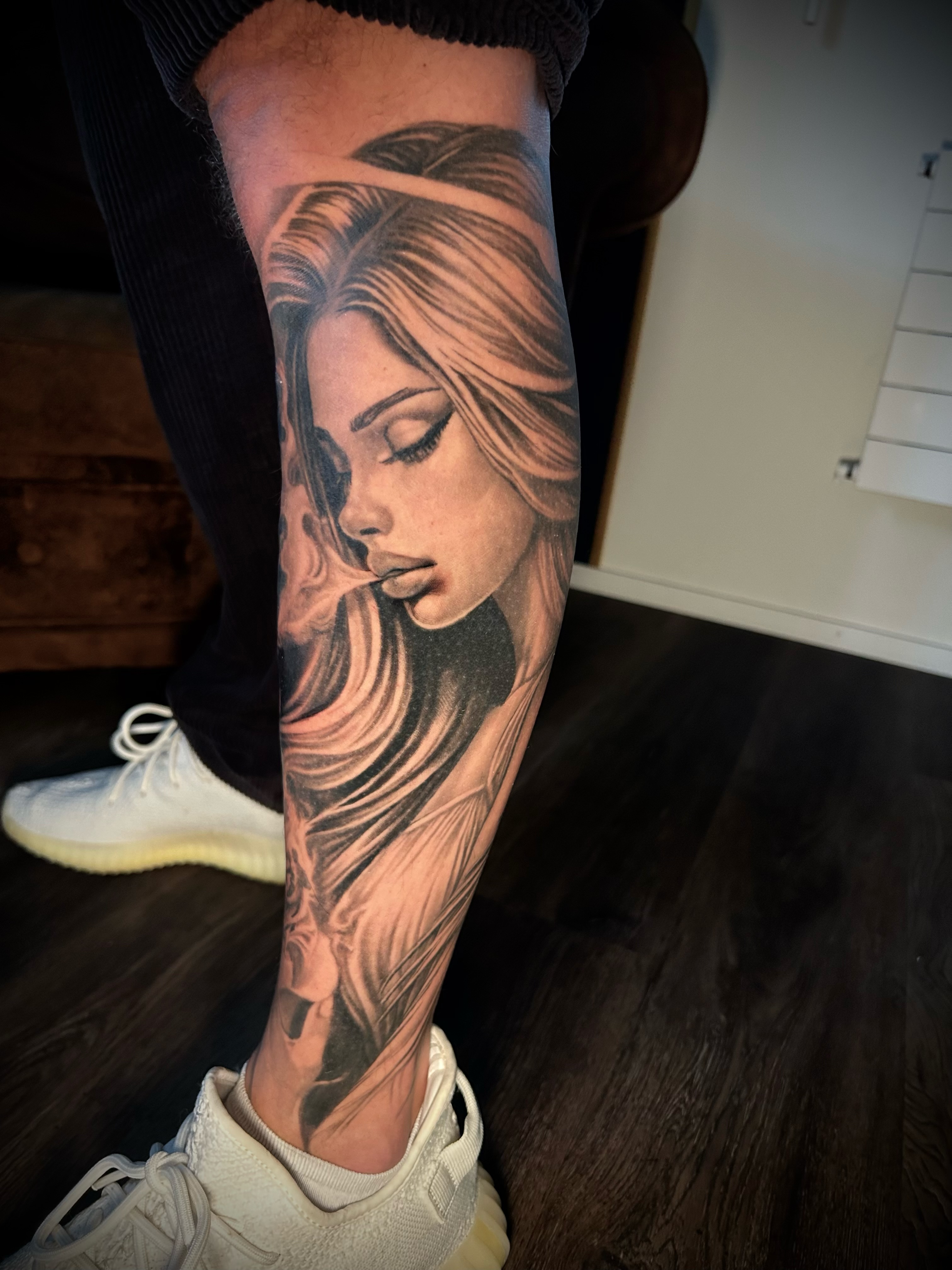 Fein gestochenes Portrait-Tattoo mit zarter Linienführung am Unterschenkel