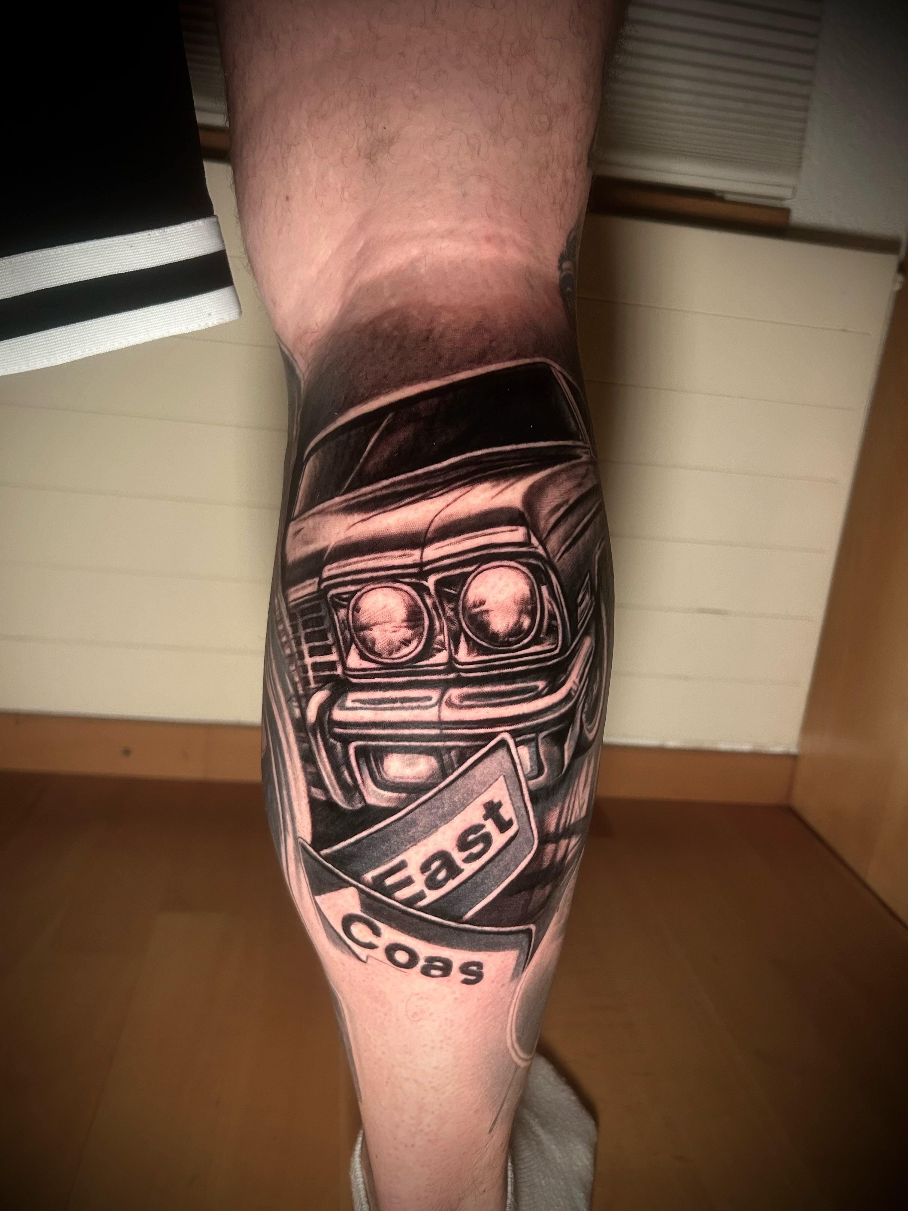 Lettering-Tattoo mit Schriftzug East Coast und Oldtimer-Motiv