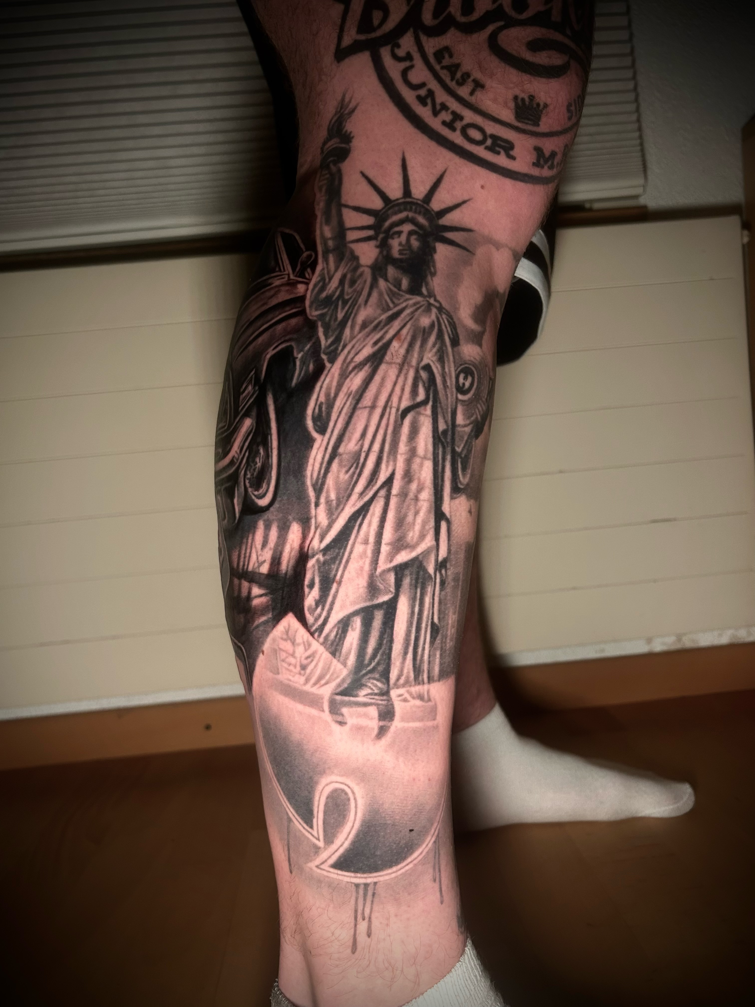 Realistisches Tattoo der Freiheitsstatue am Unterschenkel