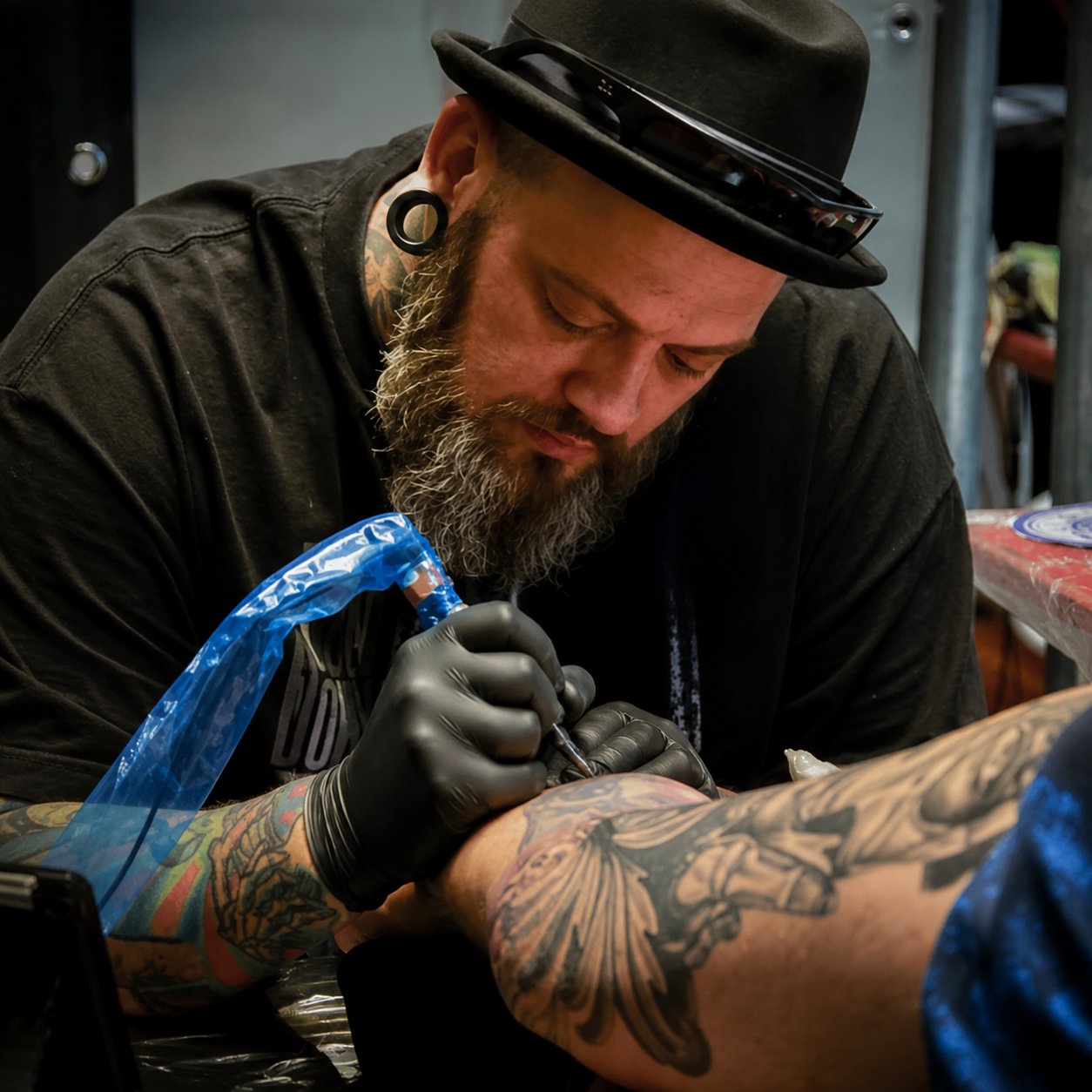 ThaHomz konzentriert bei der Arbeit an einem Tattoo